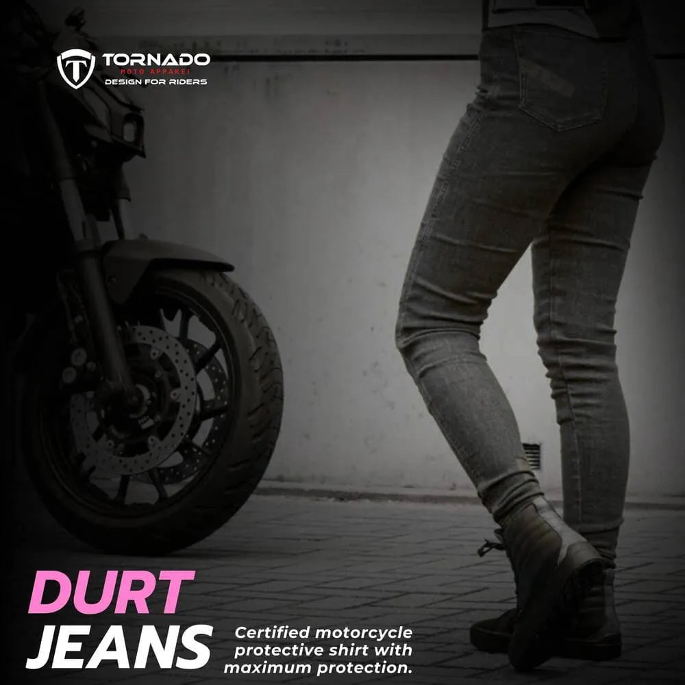 Person wearing Durt jeans next to a motorcycle with Tornado branding.